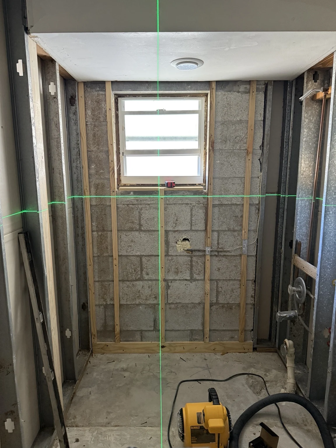 Open shower walls and framing aligned with a laser level
