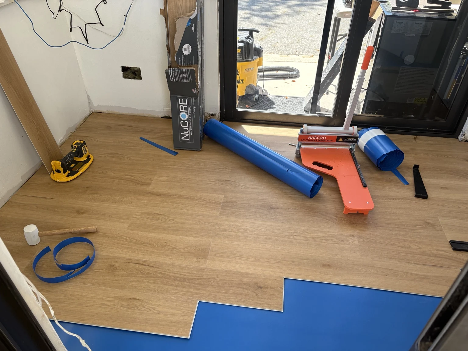 Wood-look flooring installation beside a doorway
