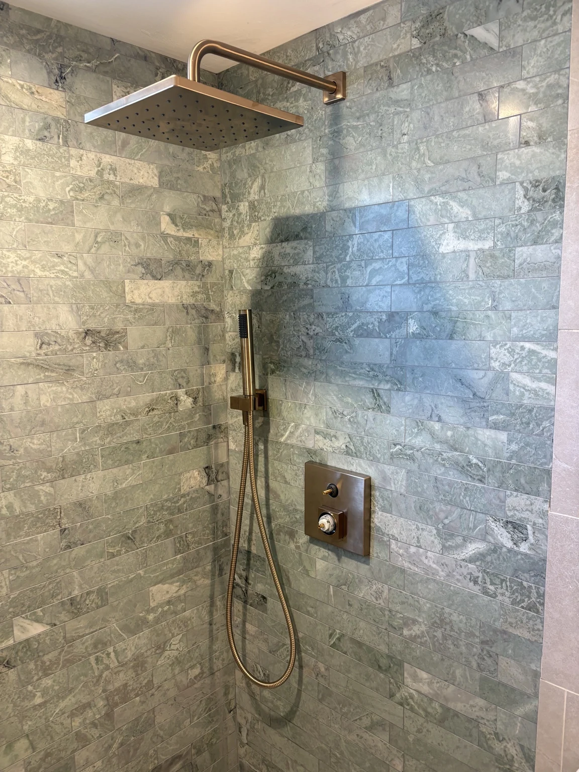 Tiled shower with rainfall showerhead and hand shower