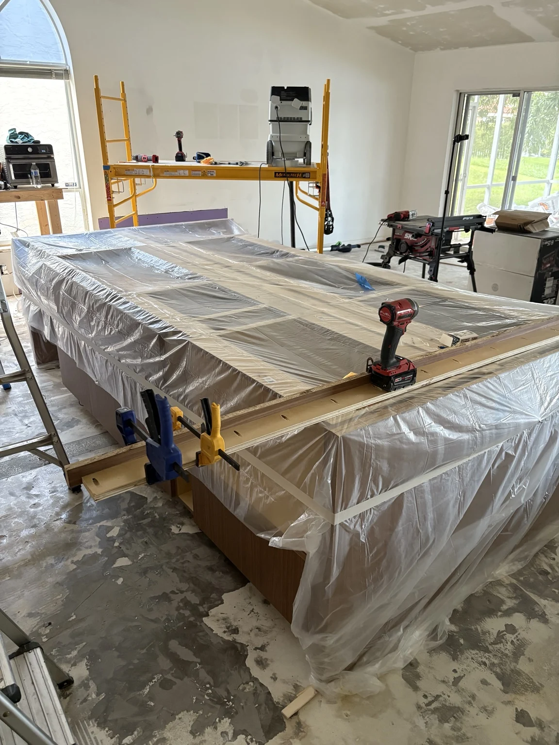 Clamped woodwork on a protected kitchen island during installation